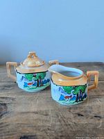 Creamer and lidded sugar bowl side by side showing matching pattern