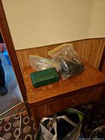 Wood side table with bags of parts and green box