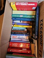 Box of assorted books showing titles and bindings