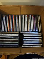 Open box showing two rows of jewel case CDs