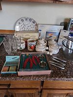Full lot showing bowls, glassware, mugs, boxed items, knives