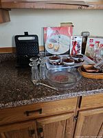 Countertop view showing waffle maker, glassware, pie plate and soup crocks