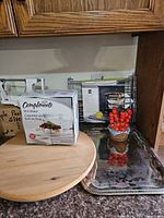 Lot overview showing brie baker box, lazy susan, picks holder, oven rack, serving tray