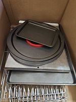 Stacked cookie sheets, pizza pans and cooling rack