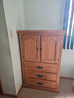 Front view of armoire closed showing doors and three drawers