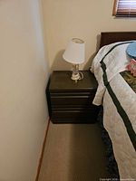 Bedside table with two drawers and lamp on top