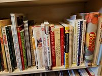 Shelf of hardcovers and spiral-bound cookbooks, titles include Canadian and diabetic topics
