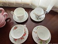 Four teacup and saucer sets displayed on table