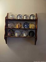 First wood shelf with assorted demitasse cup and saucer sets