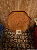 Front of octagonal Crokinole board with cardboard box for scale