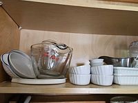 Shelf with Pyrex measuring cup, white bowls, round ramekins