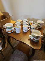 Group view of 8 mugs and 6 two-handled soup bowls on table