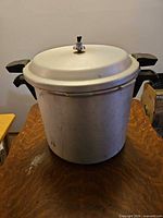 Front view of aluminum pressure canner with lid and handles