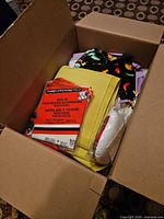 Open box showing assorted fabrics, interfacing pack and batting