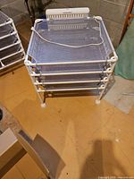 Assembled four-layer dryer showing mesh trays and frame