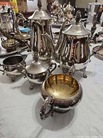 Front view of the four silver-plated pieces: coffee pot, teapot, sugar bowl, creamer