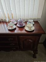 Overview of four teacup sets and tea-for-one set on sideboard