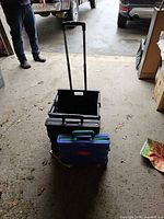 All three folded crates stacked, telescopic handle extended on one