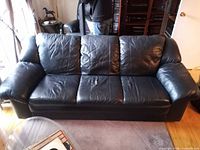 Front view of black 3-seat faux leather sofa showing overall style and condition