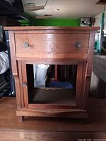 Front view of nightstand showing drawer, knobs and open shelf