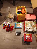 Overview showing Elmo plush, LeapFrog book, activity cube, building blocks bin, foam puzzles