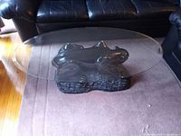 Full view of oval glass top coffee table on carpet