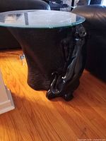 Full view of glass top and sculpted black resin base