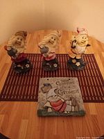 Front view of three gnome figurines and plaque