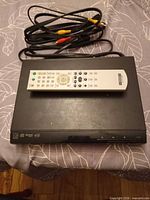 Top view of Sony DVP-SR310P player with remote and cables