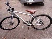 Full view of silver Vector hybrid bicycle showing frame, wheels, saddle and kickstand