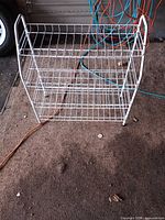Front view of white metal wire rack showing three shelves