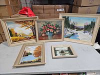 Group shot of five framed oil paintings