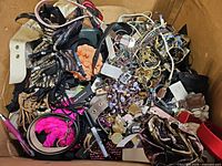 Box filled with mixed jewellery, belts, hair accessories and small costume items