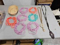 All nine necklaces laid out showing colors and pendants