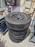 Stack of four winter tires mounted on steel rims