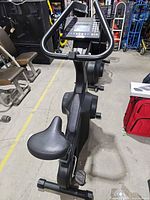Full side view of exercise bike showing frame, seat, pedals, console