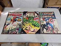 Three Marvel comic cover wood panel prints laid flat: Spider-Man, Hulk, Captain America