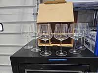 Six crystal wine glasses in front of open box