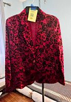 Front view of red Covington blazer on hanger showing floral velvet pattern and single button