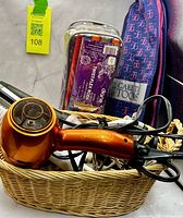 Basket holding orange hair dryer, styling irons; plastic case of twist-flex rods; Calista Tools bag in background
