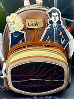 Front view showing logo plate, Sylvie and Loki appliqués, front zip pocket design, protective wrap on straps