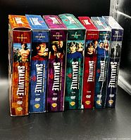 Spine view of all seven Smallville DVD box sets seasons 1-7
