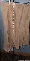 Front view of tan suede skirt with measuring tape