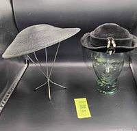 Both hats side by side on stands