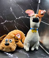 Front view of both plush dogs displaying overall appearance and tags