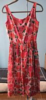 Front view of floral spectator sheath dress with tags visible