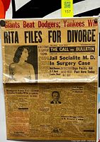 Full view of framed newspaper front page showing headlines and mounting