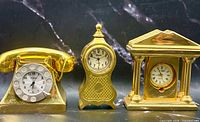 Front view of all three gold tone miniature clocks