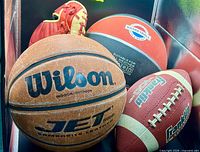 Group shot of two basketballs, football and glove