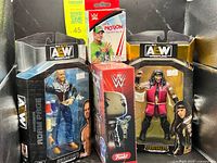 Group shot of all four sealed wrestling collectible packages